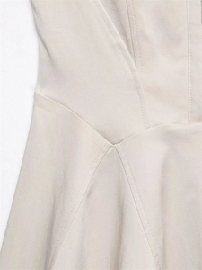 Detail shot of apricot woven twill fabric with precise vertical stitching and waist seams