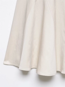 Detail view of beige A-line dress hem showing premium twill fabric texture and stitching