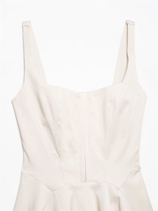 Close-up of cream sleeveless dress with square neckline and corset-style stitching details