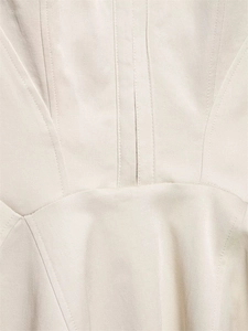 Detail showing structural corset seams and twill cotton texture on cream mini dress