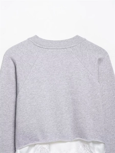 Détail d'un sweat gris avec ourlet en dentelle blanche et col rond côtelé classique