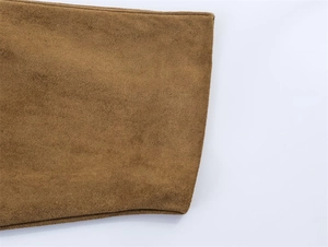 Detailed close-up of brown faux suede texture with double stitching on the sleeve cuff