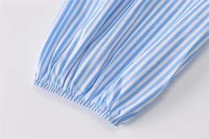 Dettaglio manica camicia a righe bianche e blu con polsini elastici arricciati