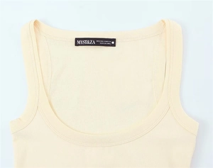 Detailed view of cream cotton tank top neckline with size label and ribbed texture