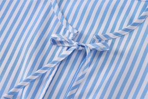 Dettaglio dello scollo della camicia in popeline a righe blu e bianche con fiocco chic