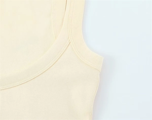 Close-up of double-needle stitching on sleeveless cream knit vest neckline