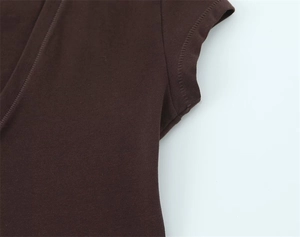 Macro shot of dark brown knit fabric with precise stitching at the V-neck and underarm seam