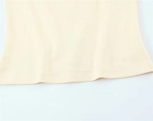 Close-up of cream knit fabric hem showing precision double-needle flat stitching detail