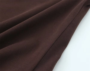 Close-up of deep coffee knit fabric with precision stitching and fine texture