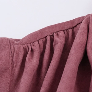 Close-up of pleated shoulder details on a dusty rose faux suede jacket for women