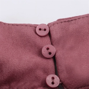 Close-up of dark purple faux suede top featuring three round buttons on the neckline