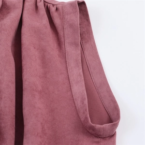 Detail of dusty pink faux suede fabric showing soft texture and pleated stitching quality