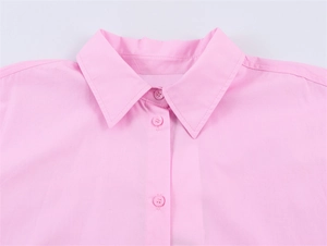 Detail shot of a soft pink poplin shirt collar with matching buttons and fine stitching