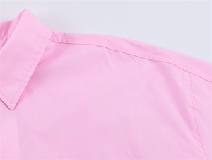 Detail of the light pink shirt collar and shoulder stitching showing high-quality fabric