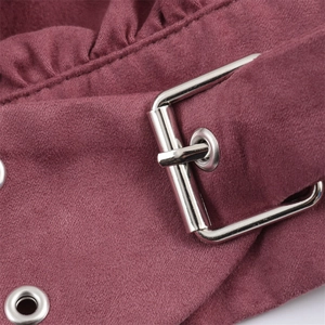 Detailed macro view of the belted waist with ruffles and silver buckle on the dusty pink top