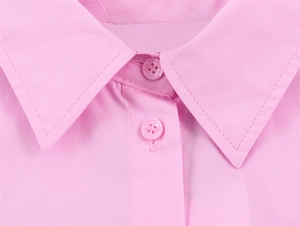 Close-up of pink poplin shirt showing classic pointed collar and neat stitching details