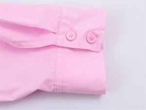 Detailed macro view of the pink poplin shirt cuffs featuring neat double resin buttons