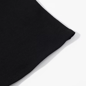 Detail view of double-stitched hem on high-quality black cotton knit halter top