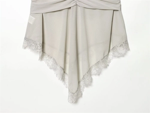 Detail of light gray top featuring delicate eyelash lace trim and asymmetric V-shape hem
