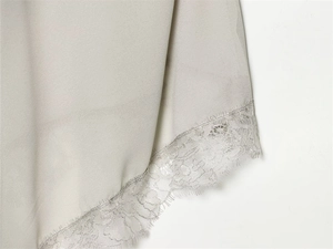 Macro shot of delicate eyelash lace hem on light grey georgette camisole top