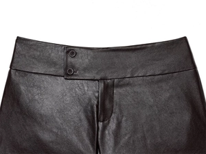 Dettaglio vita alta dei pantaloni in ecopelle marrone scuro con chiusura a due bottoni