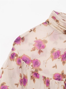 Detailed view of high-neck floral chiffon blouse featuring purple rose prints and ruffles