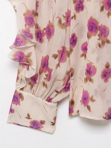 Detailed macro shot of floral chiffon sleeve with ruffled layers and button cuff