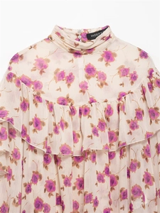 Detail of ruffled high neckline and purple floral print on elegant chiffon blouse