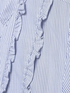 Dettaglio ravvicinato della camicia in popeline a righe bianche e blu con volant doppi