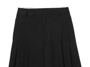 Détail de la taille et de la braguette sur ce pantalon noir classique à plis élégants