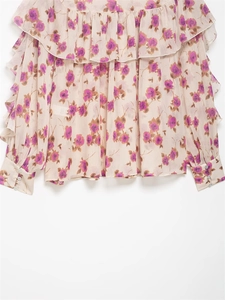 Detail view of tiered ruffles and delicate buttons on a floral long-sleeve chiffon blouse