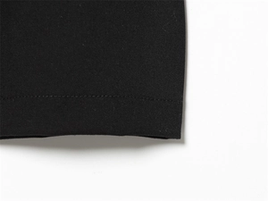 Vue détaillée de l'ourlet et de la texture du tissu d'un pantalon plissé noir chic