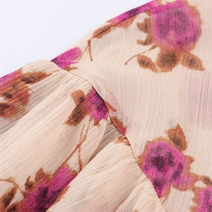 Détail de l'imprimé floral rose sur tissu beige plissé avec coutures froncées