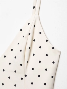 Close-up of cream polka dot fabric texture and thin straps on a spring jumpsuit