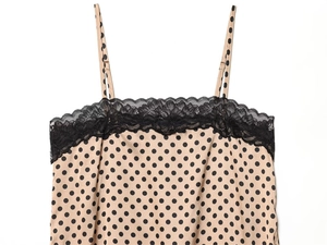 Detail of polka dot camisole featuring black lace trim and adjustable spaghetti straps