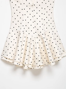 Detailed back view of a polka dot dress featuring a layered ruffle hem and hidden zipper