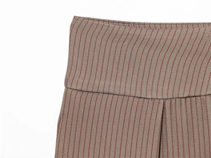 Détail de la taille haute du pantalon à chevrons en tons marron et bordeaux