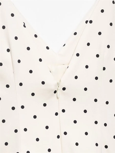 Close-up of deep V-neckline with invisible zipper on polka dot jumpsuit fabric