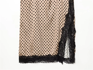 Detailed macro view of beige polka dot satin fabric with elegant black lace trim detail