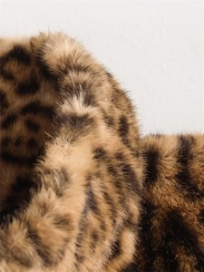 Dettaglio della texture in finta pelliccia leopardata con fibre lucide marroni e nere