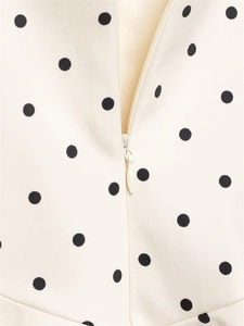 Detailed view of invisible zipper and polka dot fabric on white short jumpsuit