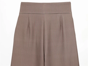 Détail de la taille haute du pantalon plissé avec fines rayures verticales marron rouge