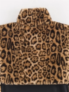 Dettaglio del gilet in pelliccia sintetica leopardata con collo alto e bordo nero