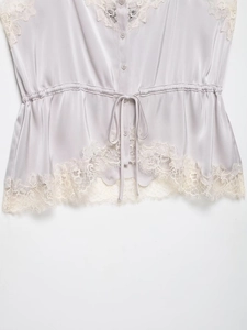 Close-up of lilac satin top with delicate lace trim, V-neckline and button details