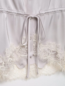 Detail view of light purple satin top featuring lace hem and drawstring waist