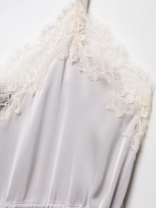 Detailed close-up of delicate eyelash lace trim on a silver satin silk camisole top