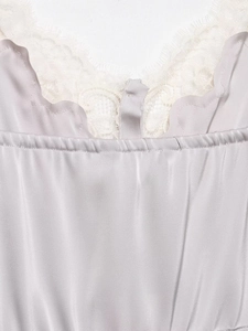 Close-up of lilac satin top featuring delicate white lace trim and smooth glossy texture