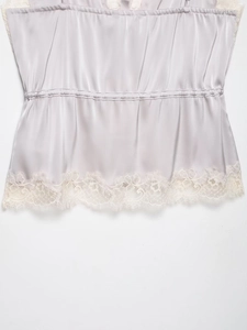 Close-up of satin camisole featuring delicate lace trim and elastic pleated texture