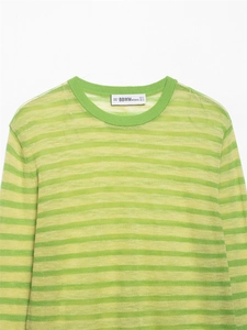 Gros plan sur l'encolure du pull rayé jaune et vert avec étiquette de la marque