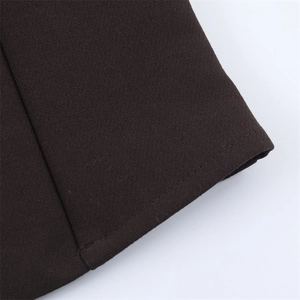 Macro view of dark brown woven fabric with precise stitching details on the hemline